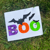 A zigzag appliqué of the word "BOO" with bats flying out of the last "O" by snugglepuppyapplique.com