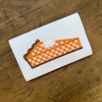 An applique of a slice of pumpkin Pie with whipped cream on top by snugglepuppyapplique.com