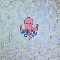 An applique of a babyish looking octopus by snugglepuppyappliquecom