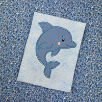 An applique of a babyish looking Dolphin by snugglepuppqappliqe.com