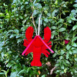 An in the hoop lobster ornament made of felt with ribbon hanger and feelers by snugglepuppyapplique.com