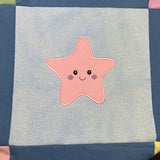 An applique of a smiling starfish by snugglepuppyapplique.com