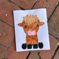An applique of a babyish looking Highland Cow in 6 sizes by snugglepuppyapplique.com