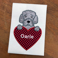 An applique of a curly haired Portuguese Water Dog with  paws on a heart by snugglepuppyapplique.com