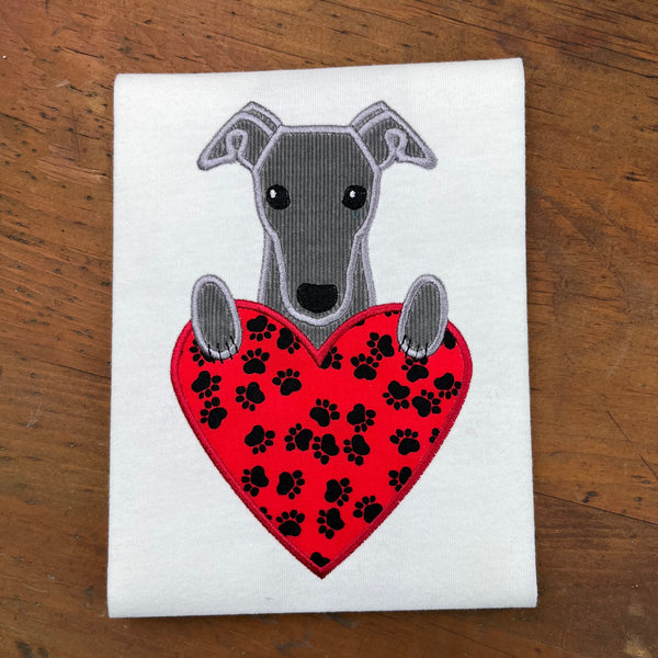 An applique of a greyhound dog with its paws on a heart Valentine design by snugglepuppyapplique.com