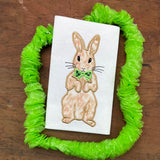An appliqué of an upright rabbit wearing a bowtie by snugglepuppyapplique.com