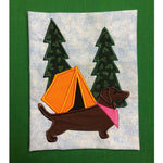 June Dachshund applique embroidery design, Dachshund in profile with a bandanna around his neck and a tent and two evergreen trees in the background
