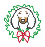 An applique of a long haired black and tan dachshund with it's head through a christmas wreath by snugglepuppyapplique.com