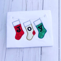 An applique of three stockings hanging on a line with "J O Y" embroidered one letter on each  stocking by snugglepuppyapplique.com
