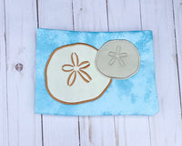 An appliqué of two sand dollars by snugglepuppyapplique.com