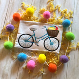 An applique of a bicycle with a basket and a beach ball inside it.  by snugglepuppyapplique.com